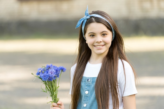 Little girl cornflowers bouquet holiday greetings, birthday gift concept.