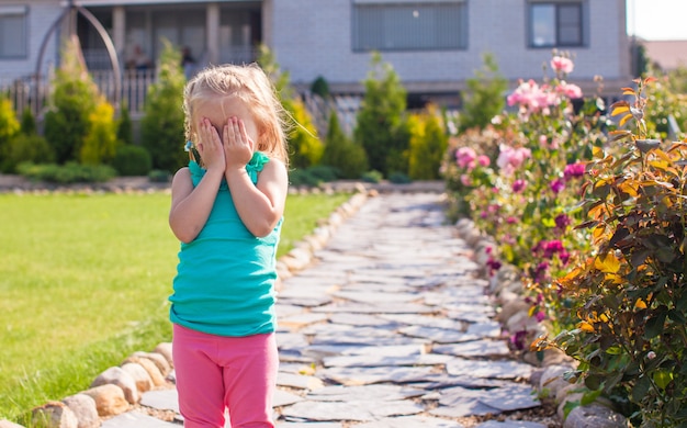 Little girl covering her face, does not want be photographed