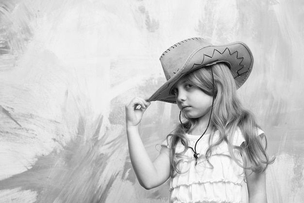 Little girl in cowboy hat on colorful background copy space