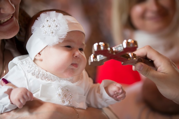 To a little girl and a cross at the ceremony of baptism.Baptizing a child