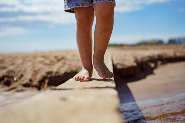 Little girl crossing stream over handmade plank bridge