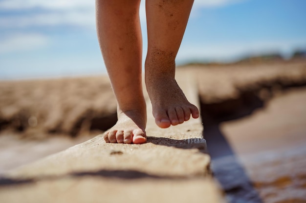 Bambina che attraversa il flusso sopra il ponte fatto a mano della plancia