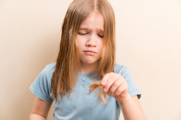 La bambina si taglia i trucchi per la cura dei capelli