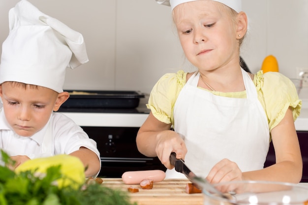 Little girl cutting ingredients for homemade pizza