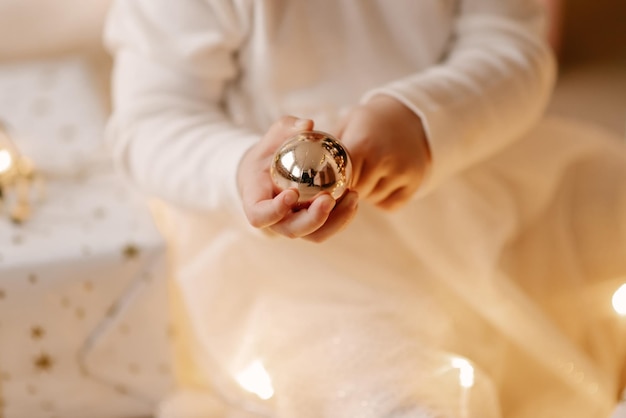 A little girl decorates a Christmas tree on her first New Year