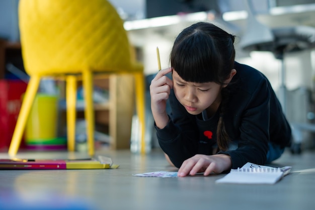 写真 宿題をしている小さな女の子子供書く紙教育の概念