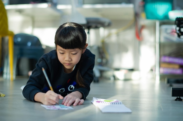 宿題をしている小さな女の子子供書く紙教育の概念