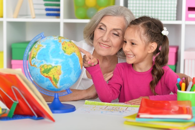 Little girl doing homework with her grandmother at home