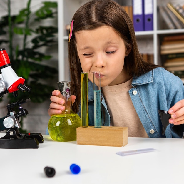 Photo little girl doing science experiments with test tubes