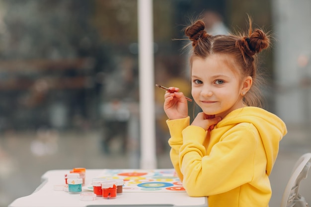 Little girl drawing art picture Painting with brush and watercolor paints