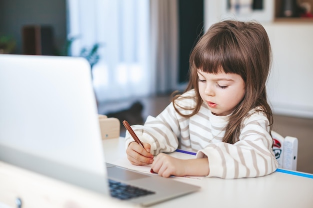 Little girl drawing on the online art lesson