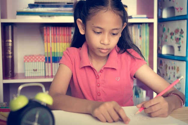 Little girl drawing on table at home education concept