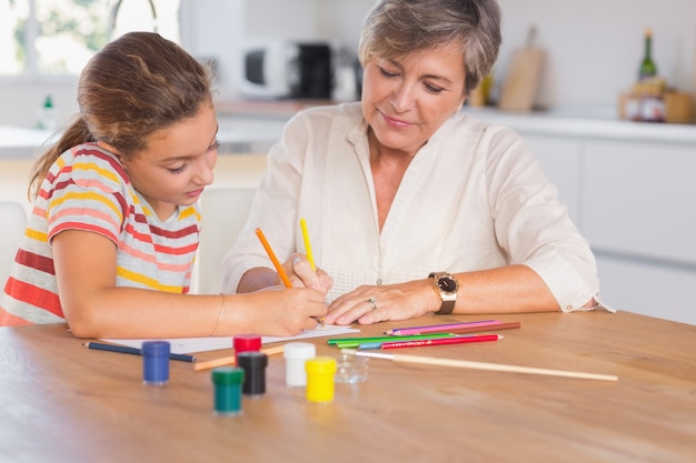 Little girl drawing with her grandmother focused