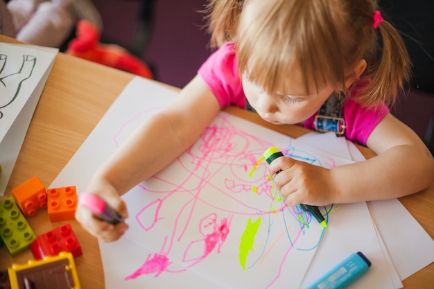 Little girl drawing with marker pens