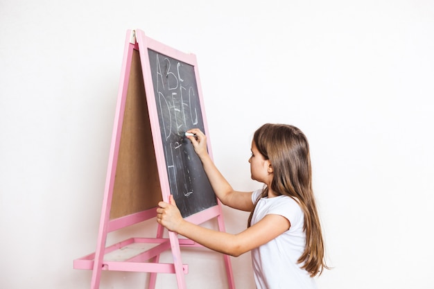 Little girl draws chalk board