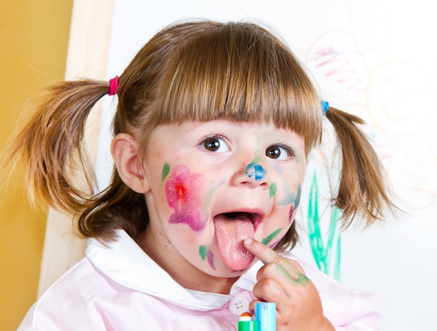 little girl draws paints 