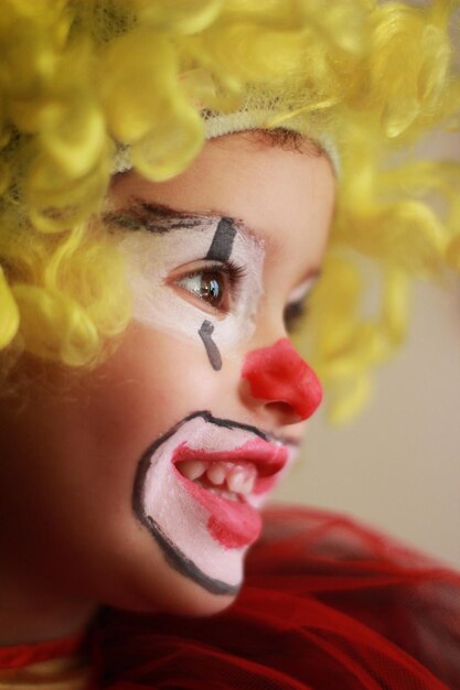 Photo little girl dressed as a clown with blonde wig profile portrait photo