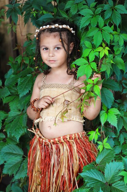 Little girl dressed as a native outdoors in summer. High quality photo