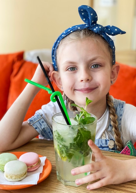 Little girl drinking non-alcoholic mojito  in a cafe