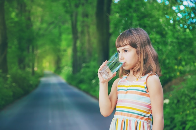 Little girl drinking water from a glass