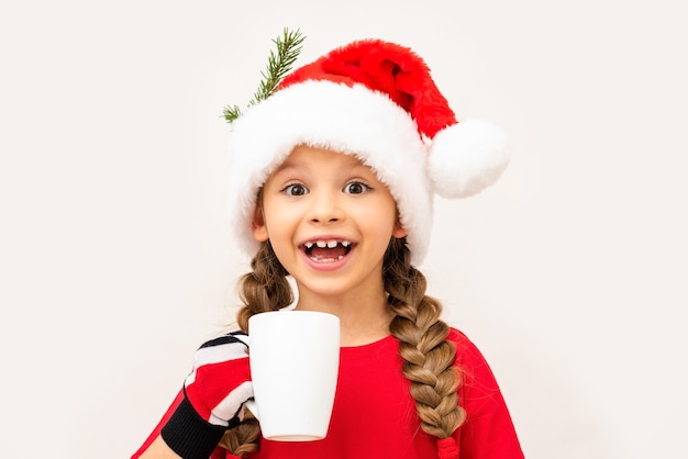 A little girl drinks a Christmas drink.