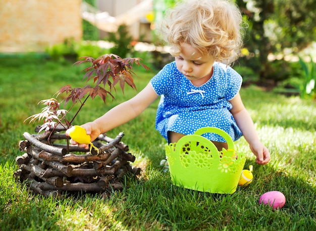 Little Girl on an Easter Egg hunt on a meadow in spring