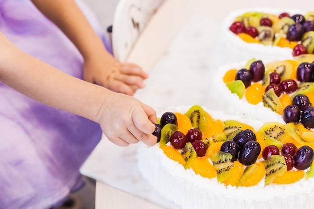 Little girl eating cake with her hands