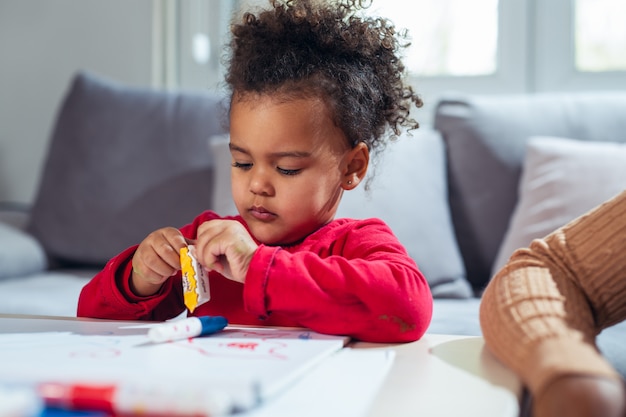 Little girl eating candies at home