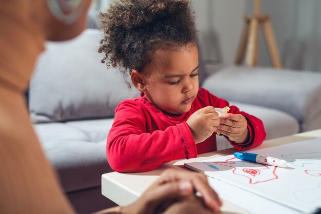 Bambina che mangia le caramelle a casa