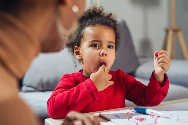 Little girl eating candies at home 