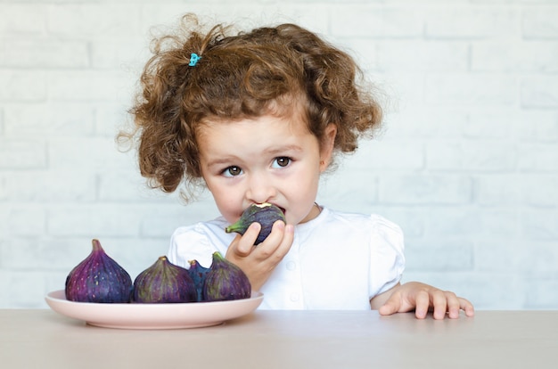 Photo little girl eating figs portrait
