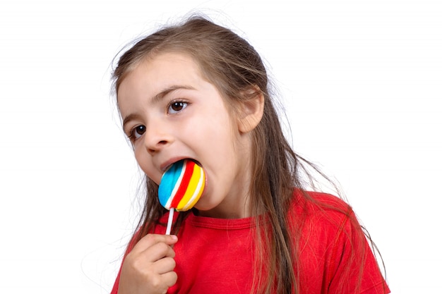 막대 사탕을 먹는 어린 소녀.