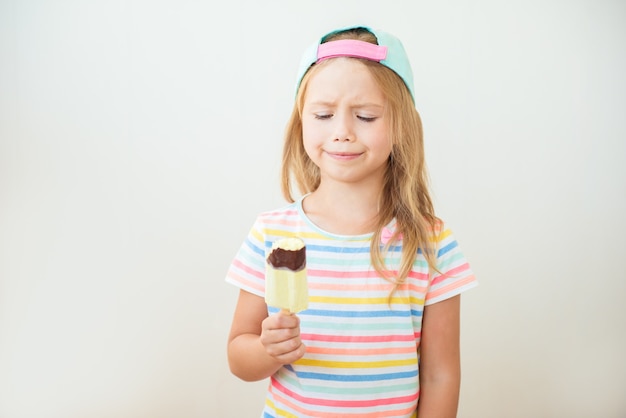 棒で甘いアイスクリームを食べる少女