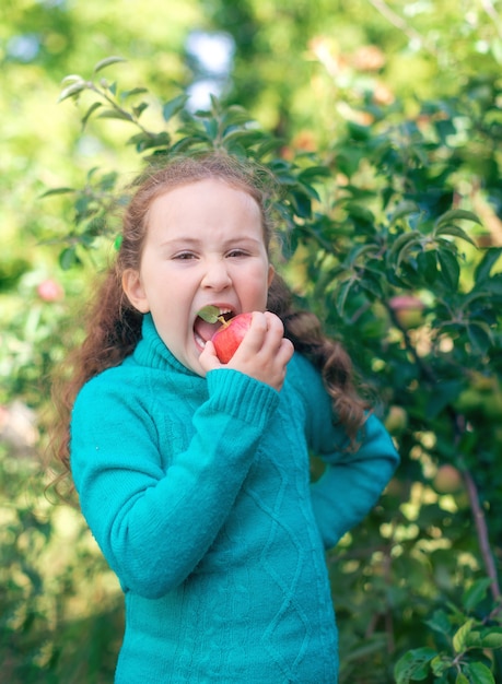 A little girl eats an Apple