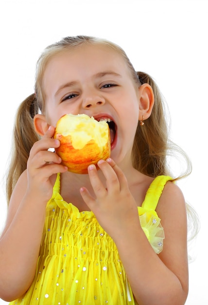 Little girl eats an apple