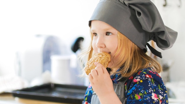 Little girl eats homemade cookies with jam prepared with their own hands close up