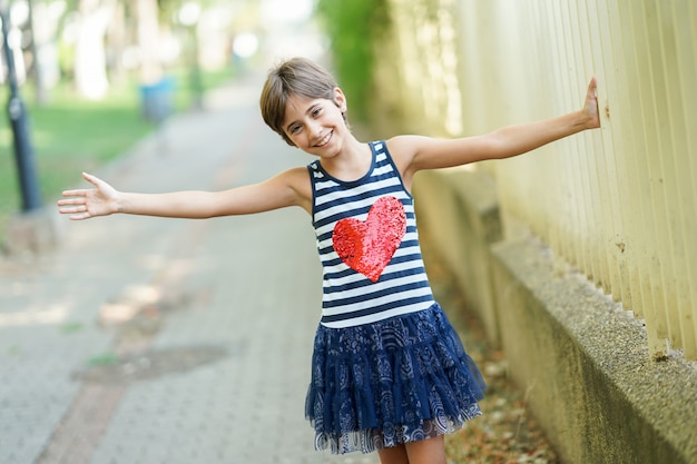 Photo little girl, eight years old, having fun outdoors.