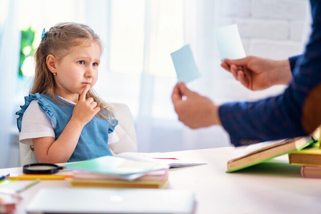 自宅で教師とのレッスンに従事している小さな女の子