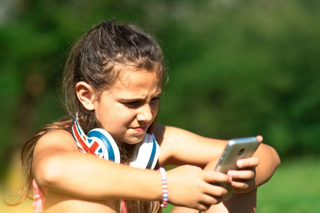 Little girl explores social networks with her smartphone