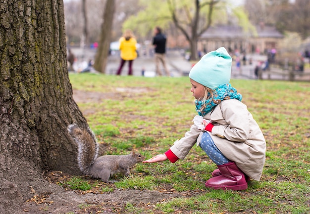 Little girl feeds a squirrel in Central park, New York, America