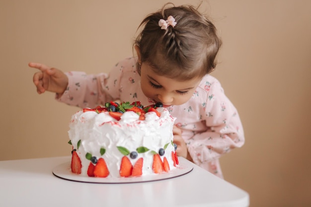 사진 어린 소녀 처음 맛 bitday 케이크 딸기와 함께 케이크를 시음하는 아름다운 드레스에 귀여운 소녀