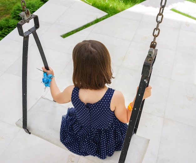 Little girl flying on swing in house yard