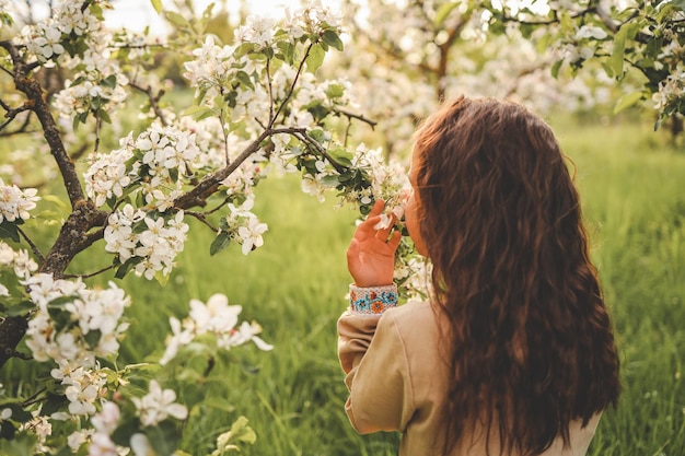 Little girl in the garden enjoying the flowering trees