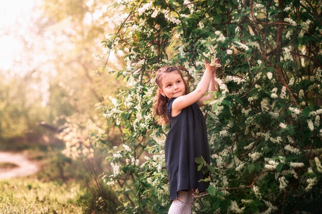 little girl in the garden with blooming trees