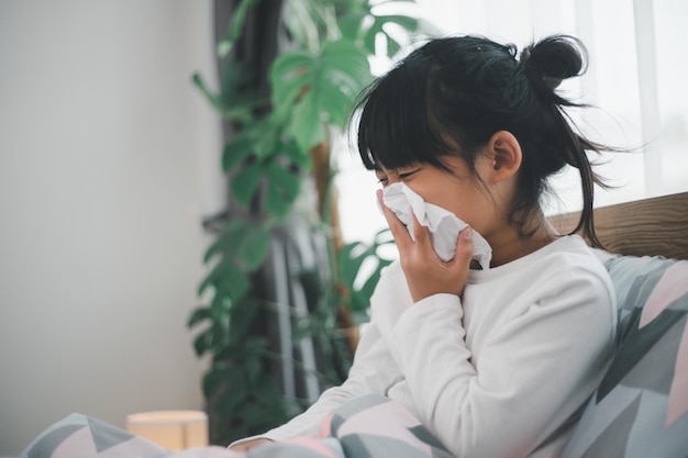 Little girl gets cold and blows her nose at home