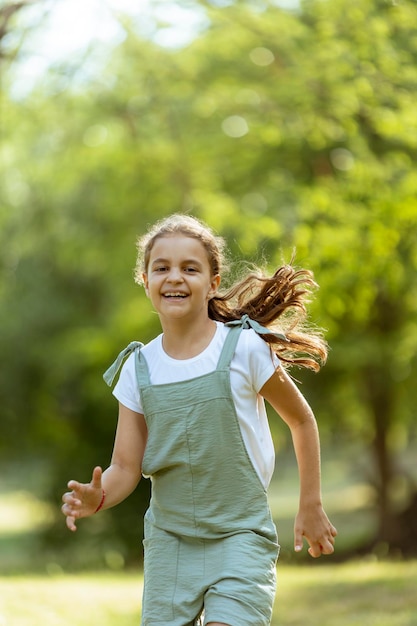 Bambina che corre felicemente nel parco