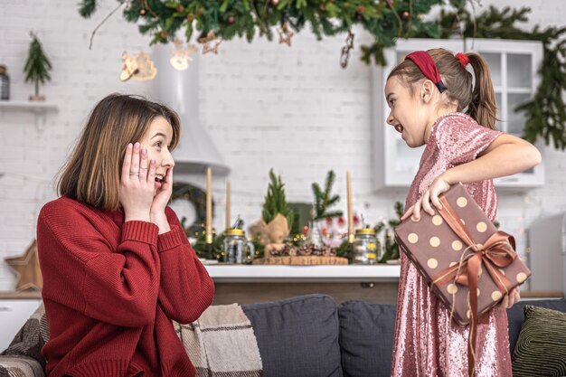 Little girl gives mom a festive gift box christmas surprise