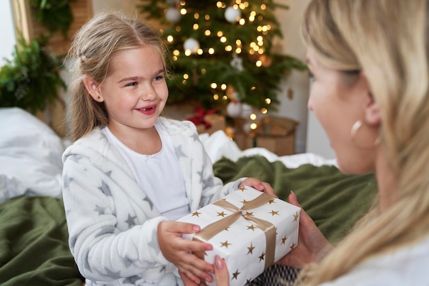 母にクリスマスプレゼントを贈る小さな女の子