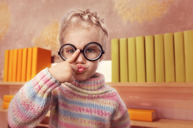 Foto la bambina con gli occhiali fa le facce