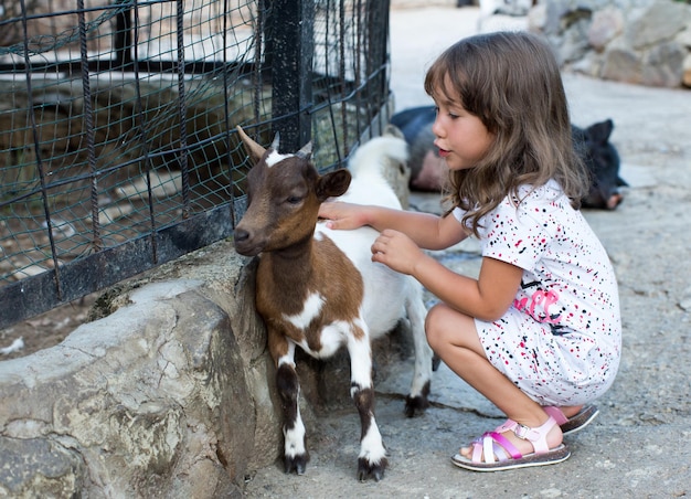 Little girl and goat in nature.